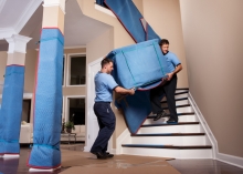 Carrying a pad-wrapped dresser down a stairway