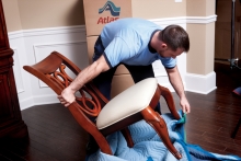 Our movers pad wrapping a customer's dining room chair