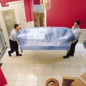 Moving a stretch-wrapped sofa into a customer's residence